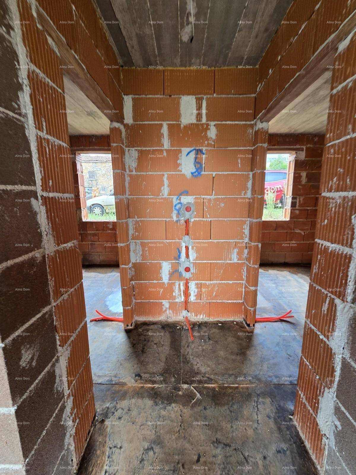 Blick durch eine Türöffnung in einen weiteren Raum im Rohbau mit zwei Fensteröffnungen.