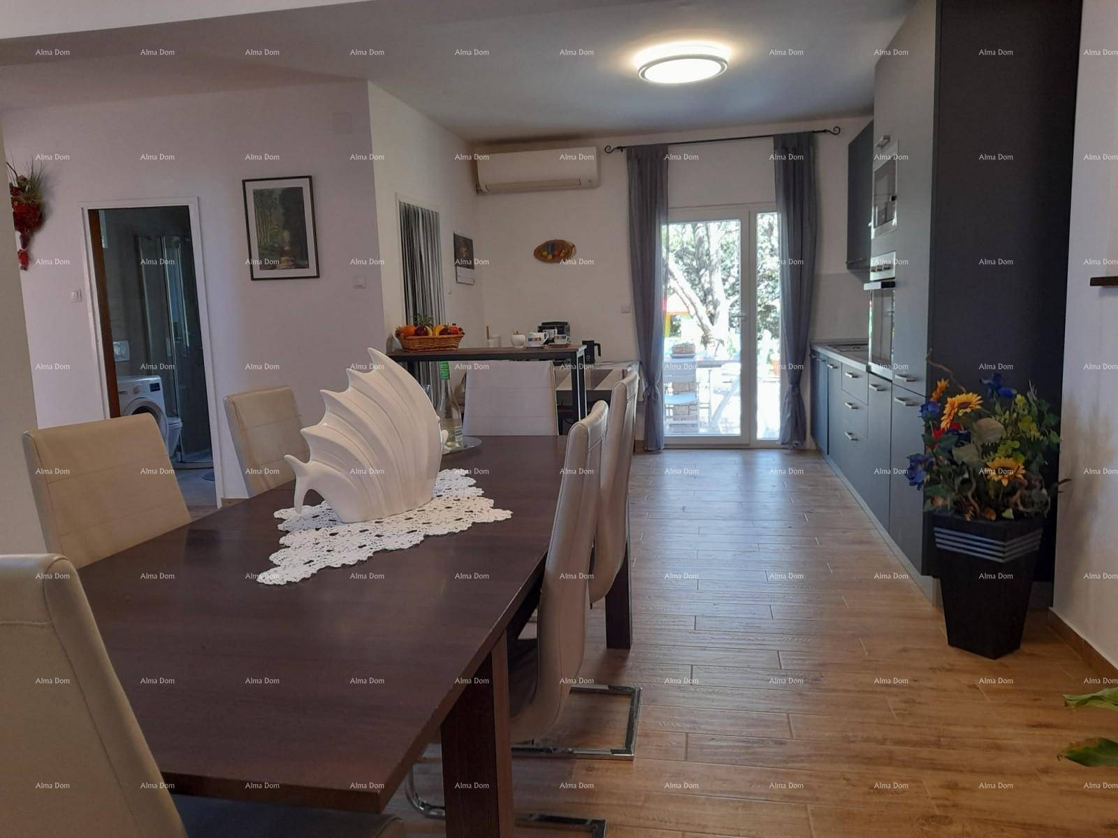 Heller Wohn- und Essbereich mit Zugang zur Terrasse und moderner Küche im Hintergrund.