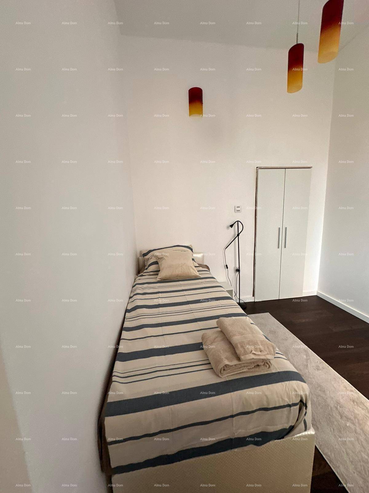 Gemütliches Schlafzimmer mit Einzelbett, modernem Kleiderschrank und dunklem Holzboden.
