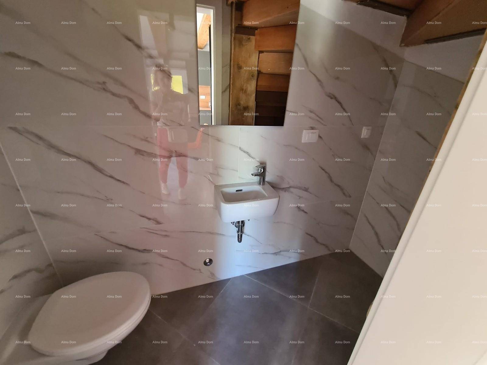Kleines WC mit modernen Marmorfliesen, wandmontiertem Waschbecken und Toilette.