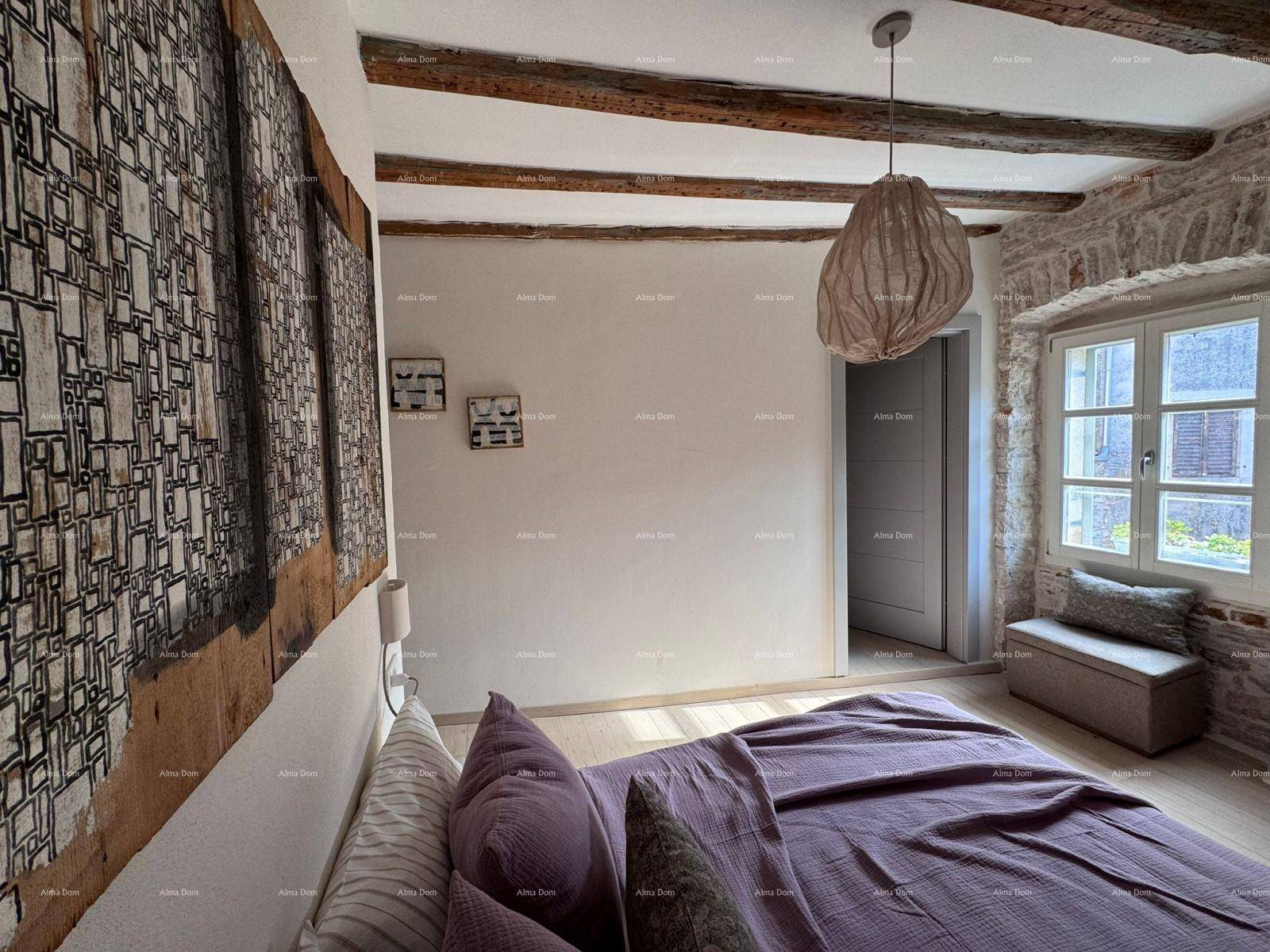 Gemütliches Schlafzimmer mit Holzbalken, Steinwand und einem großen Kunstwerk über dem Bett.