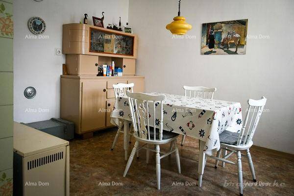 Essbereich mit Holztisch, weißen Stühlen und einem Buffetschrank in hellem Holzton.