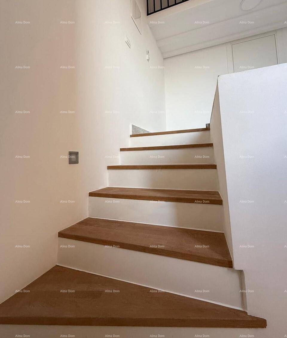 Geschwungene Holztreppe mit klaren Linien und weißem Geländer, die zu den oberen Etagen führt.