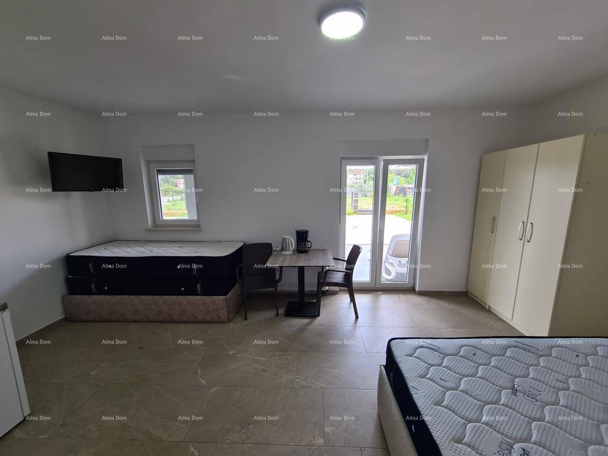 Geräumiges Schlafzimmer mit zwei Betten, kleinem Esstisch und Zugang zum Außenbereich.