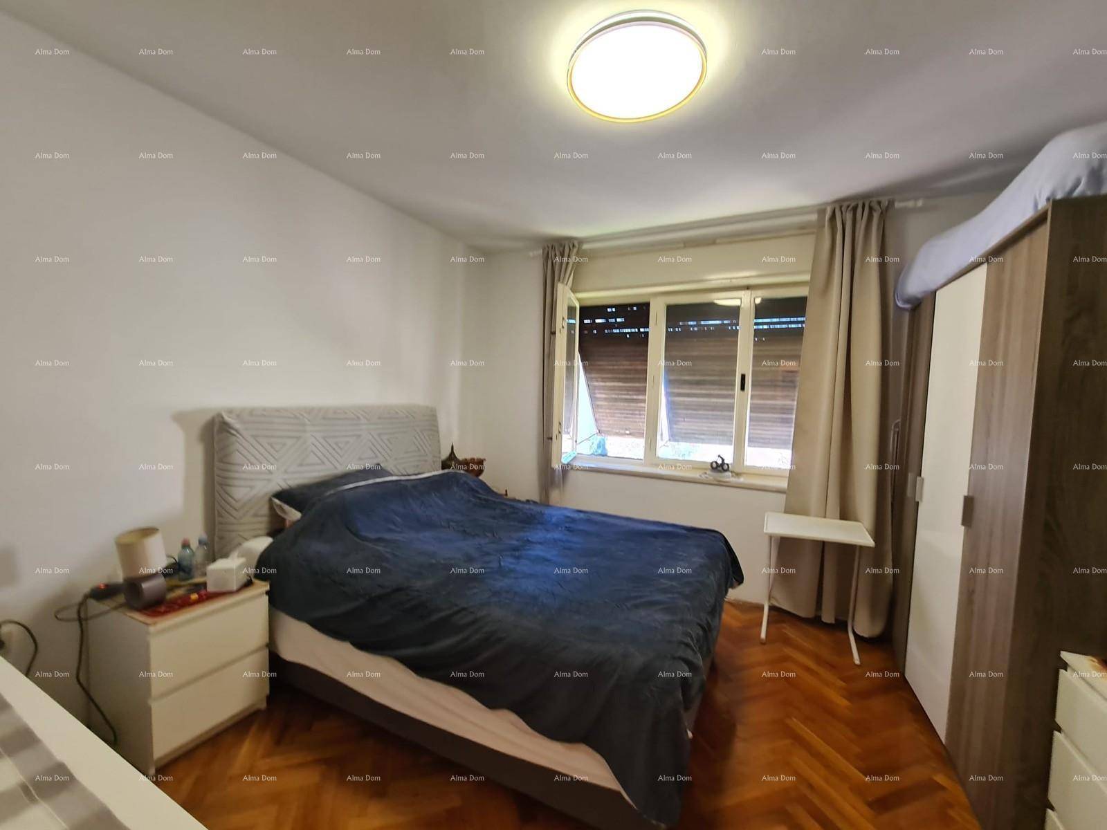 Schlafzimmer mit Doppelbett, Parkettboden und Fenster mit Rollläden.