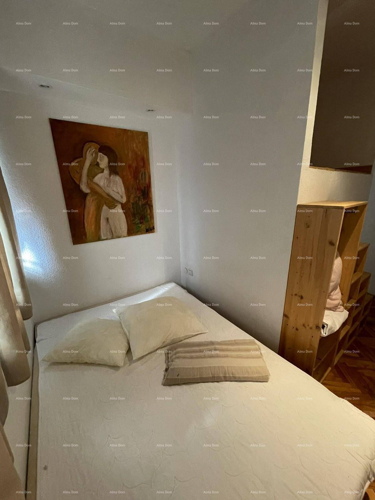 Schlafzimmer mit Bett, Holzboden und Kunst an der Wand, gemütlich eingerichtet.