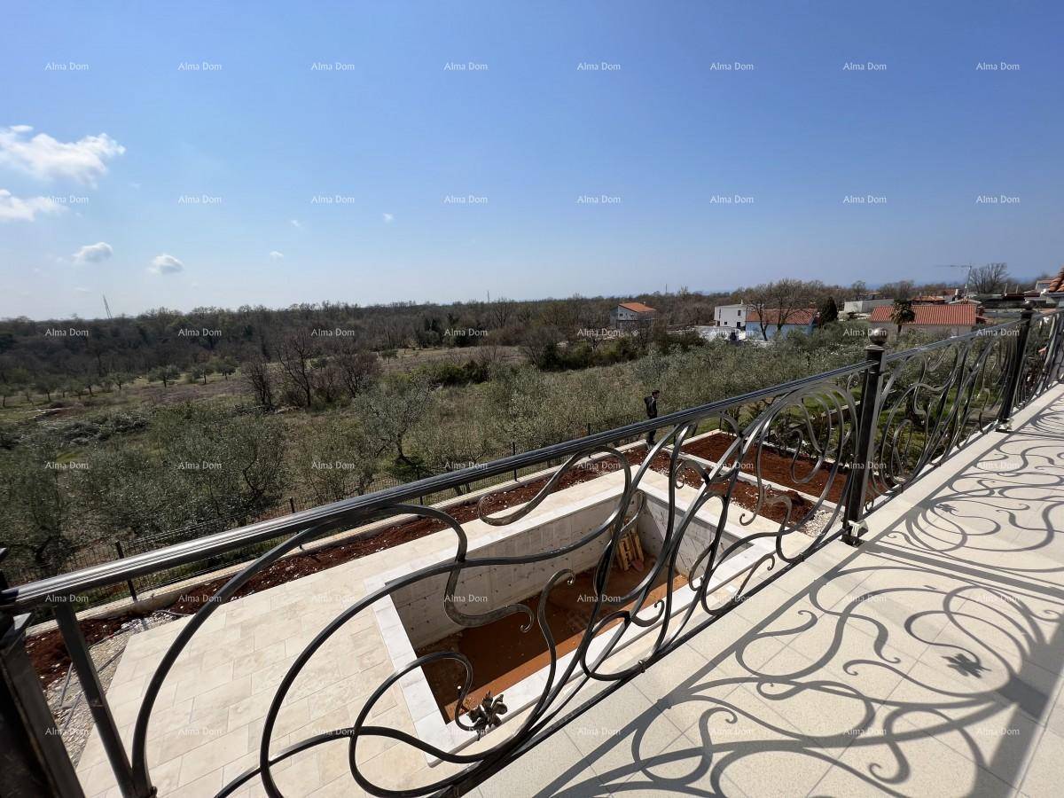 Großer Balkon mit schmiedeeisernem Geländer und weitem Blick über die grüne Landschaft und den Poolbereich.
