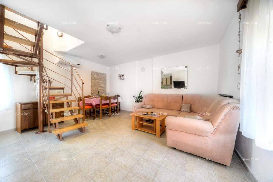 Heller Wohnbereich mit bequemer Couch, Essbereich und offener Treppe zum Obergeschoss.