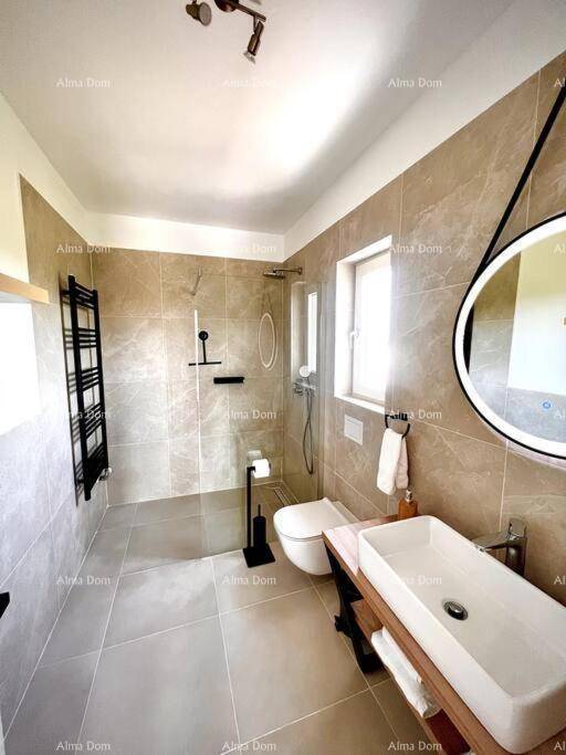 Modernes Badezimmer mit Fenster, begehbarer Dusche und elegantem Waschtisch.