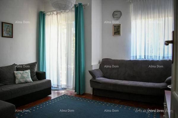 Wohnzimmer mit zwei Sofas, großen Fenstern und Vorhängen in Türkis und Weiß.