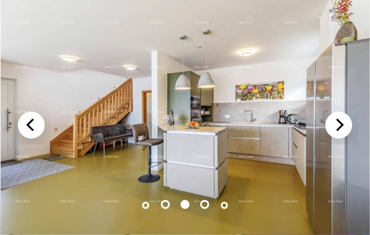 Offener Wohnbereich mit moderner Küche, Essbereich und Holztreppe zum Obergeschoss.
