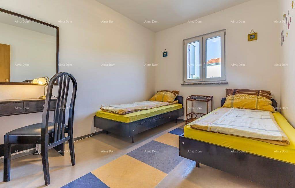 Schlafzimmer mit zwei Einzelbetten, Schreibtisch und Fenster für natürliches Tageslicht.