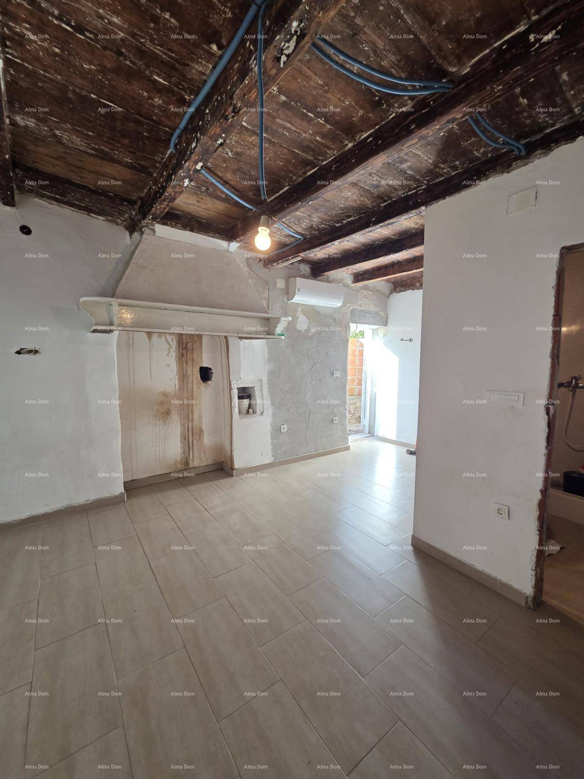 Großer Raum im Rohbau mit Fliesenboden, sichtbaren Holzbalken und Vorbereitungen für Installationen.