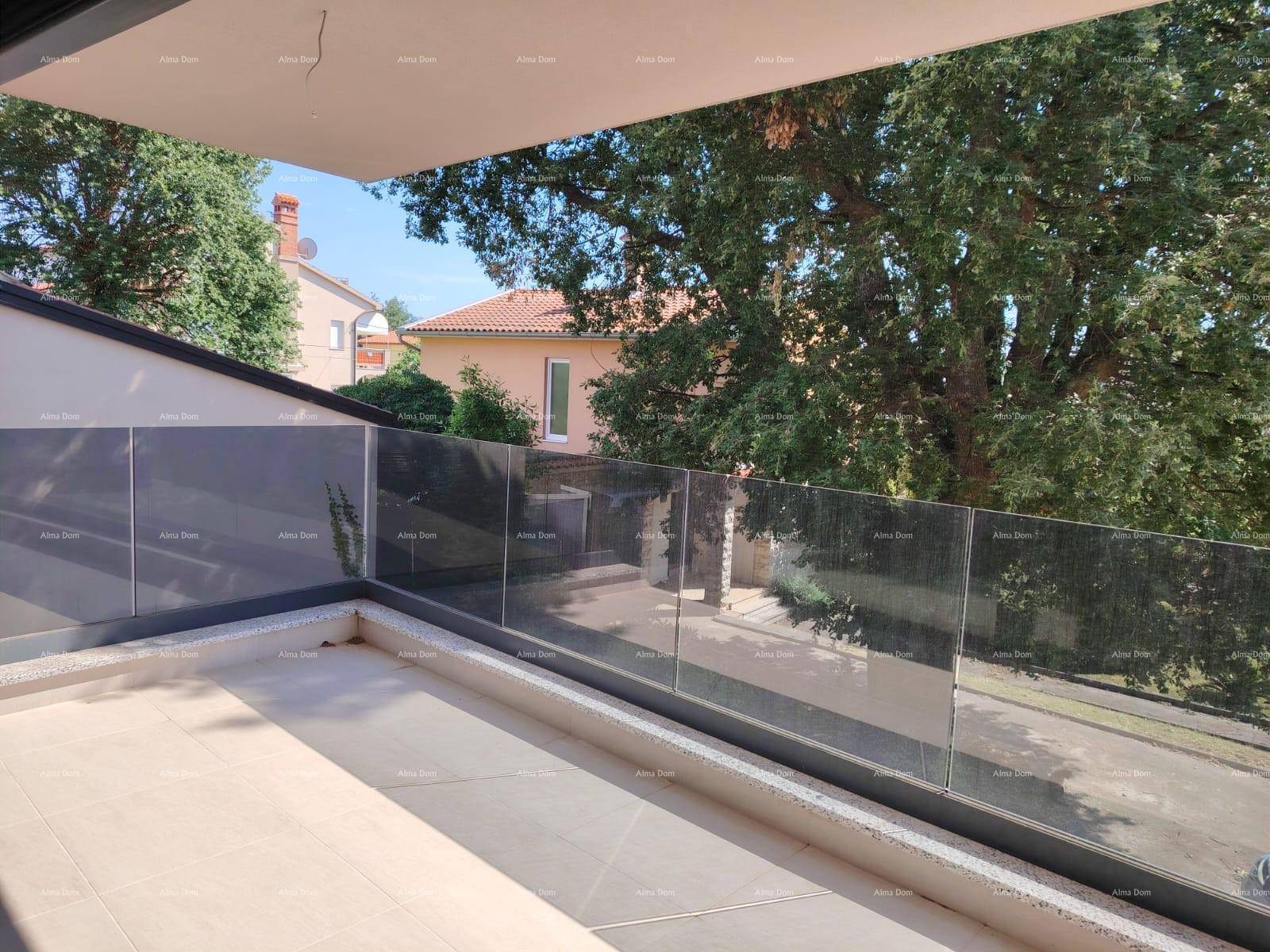 Geräumiger Balkon mit Glasgeländer und weitem Blick auf grüne Bäume und die Umgebung.