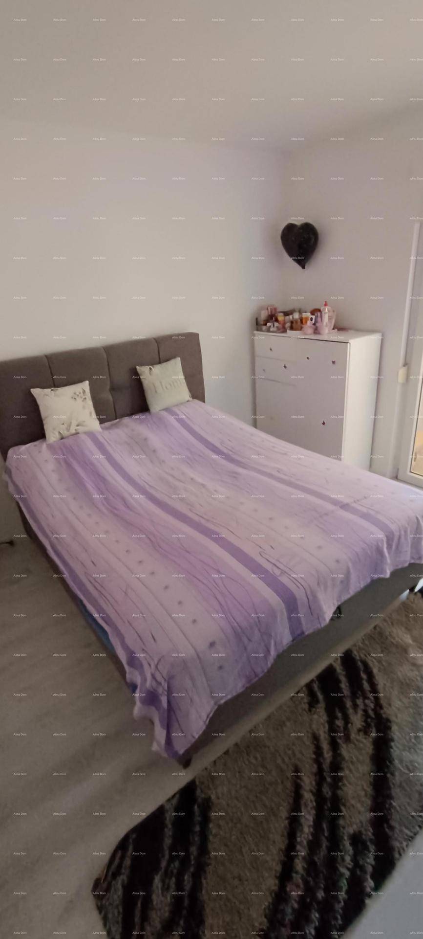 Schlafzimmer mit Doppelbett, Nachttischen und einem Kleiderschrank in schlichtem Design.