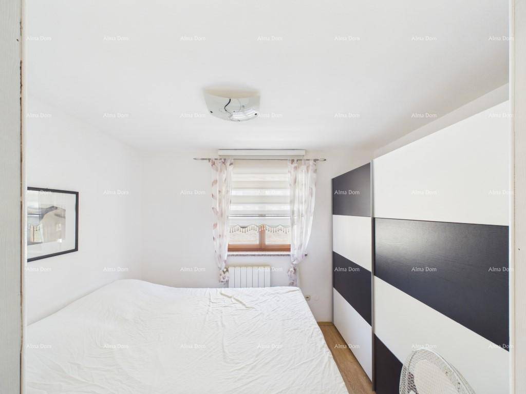 Helles Schlafzimmer mit Doppelbett, modernem schwarz-weißem Kleiderschrank und Fenster für Tageslicht.