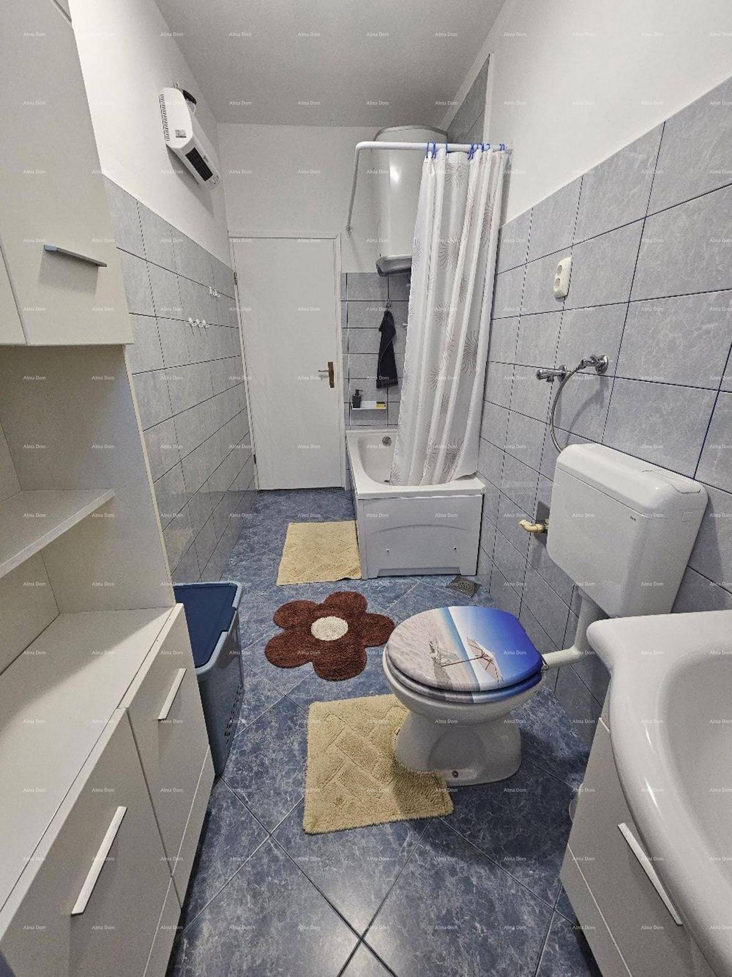 Badezimmer mit Badewanne, WC, Waschbecken und blauen Fliesen an den Wänden.