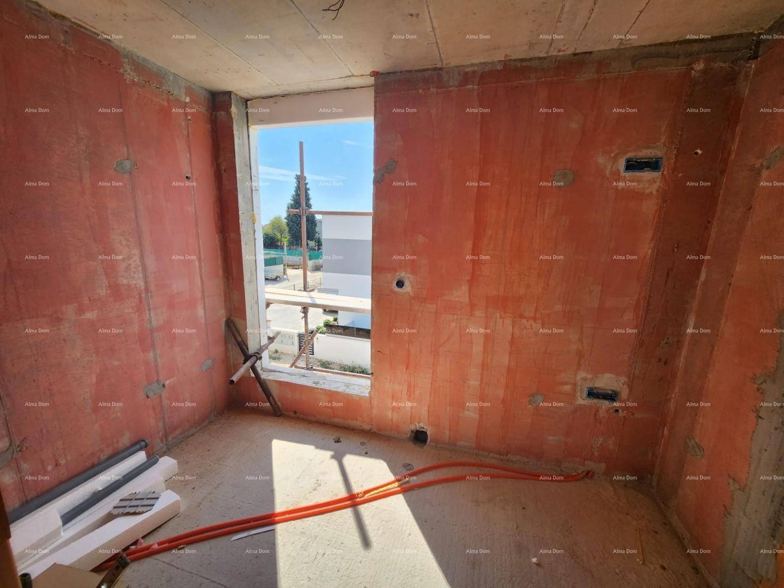 Rohbau eines Raumes mit unverputzten Wänden, Betonboden und einem Fenster mit Blick nach draußen.