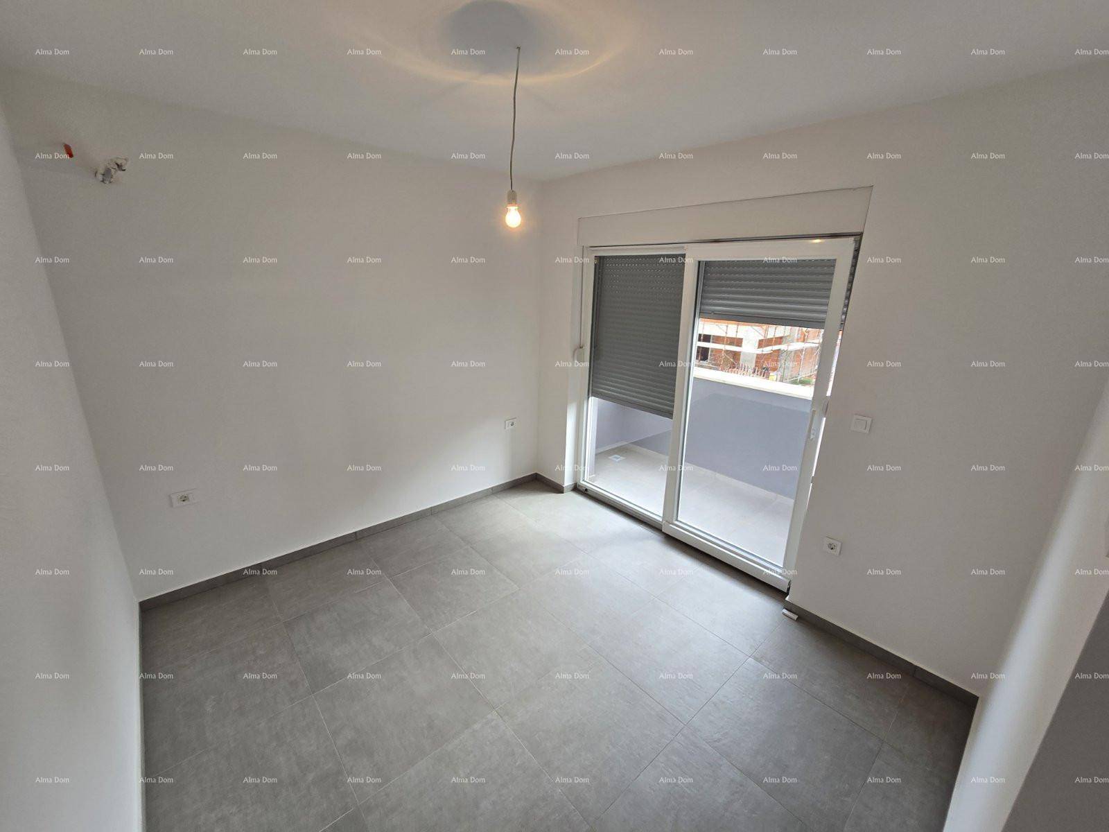 Helles Zimmer mit grauen Fliesenboden und einer großen Schiebetür zum Balkon.