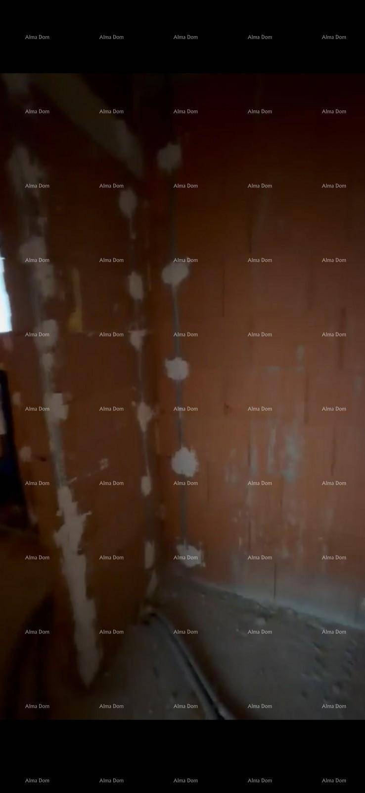Nahaufnahme einer unverputzten Ziegelwand im Rohbau mit ersten Putzspuren.