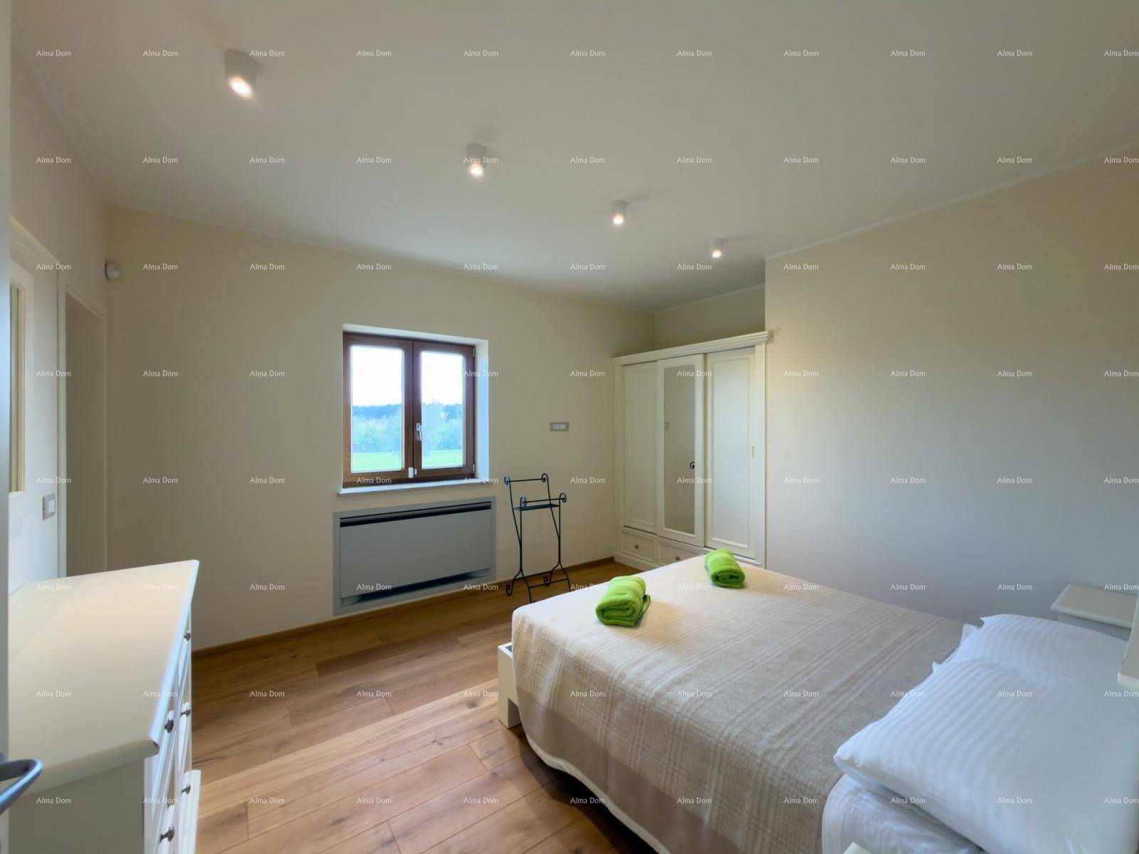 Helles Schlafzimmer mit Holzboden, Doppelbett, Kleiderschrank und Fenster mit Blick ins Grüne.