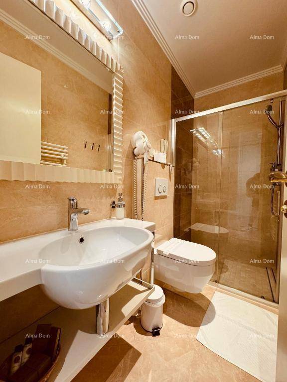 Modernes Badezimmer mit begehbarer Dusche, wandhängendem WC und eleganten Fliesen in Erdtönen.