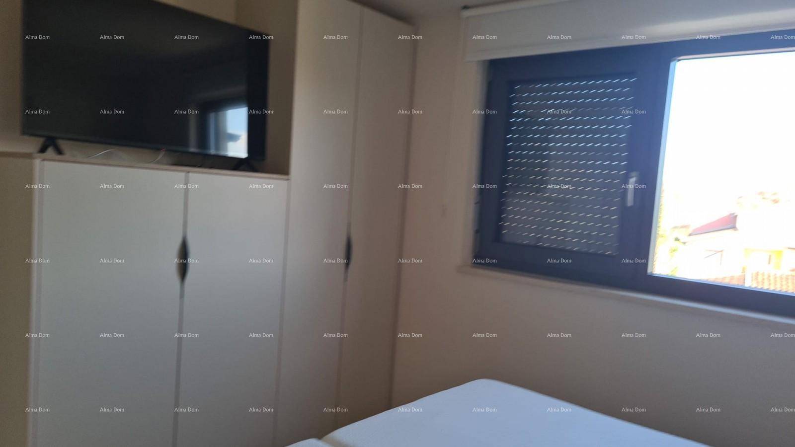 Schlafzimmer mit Einbauschränken, Fernseher und Fenster mit Rollladen für Privatsphäre.