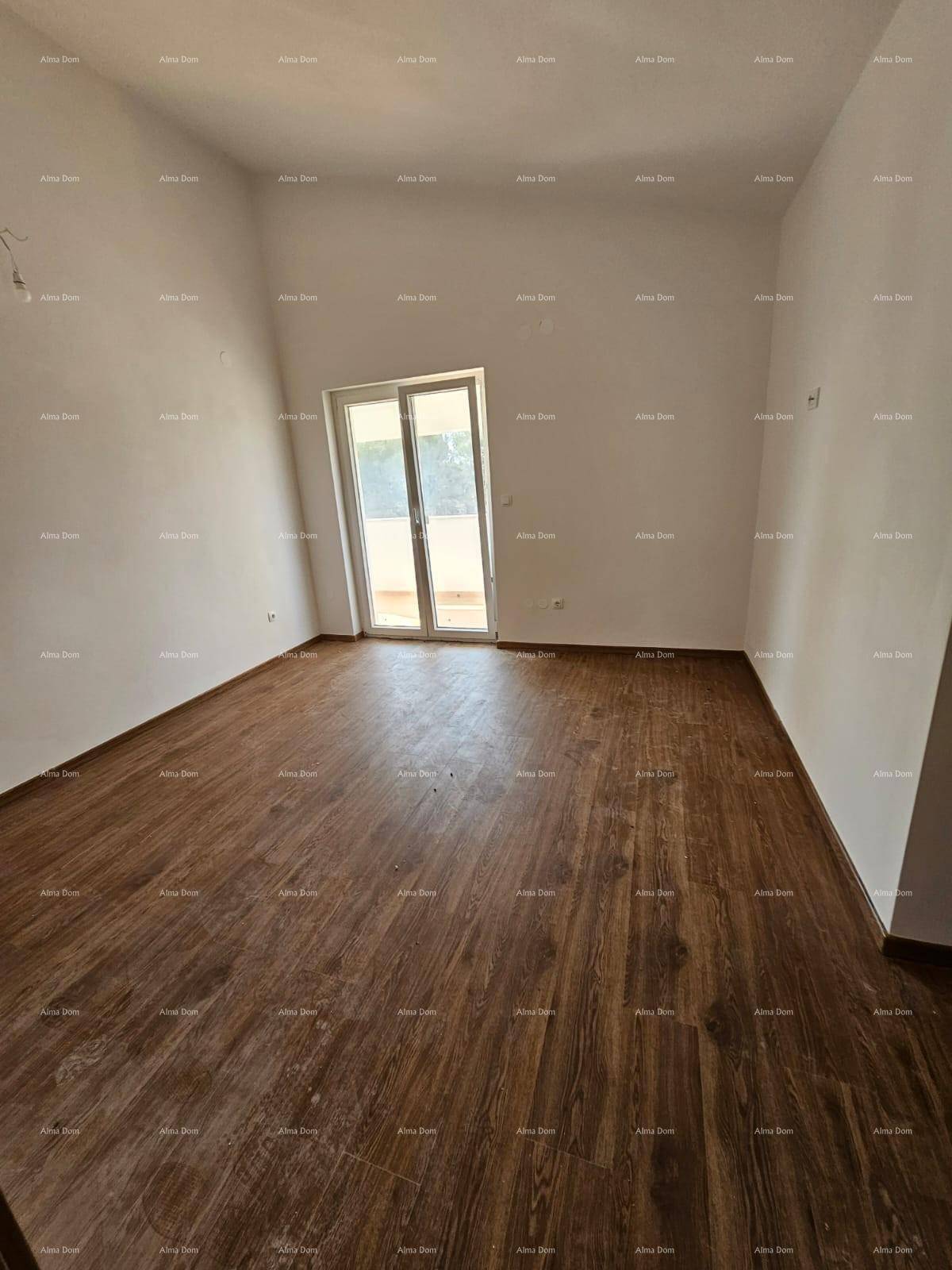 Geräumiges Schlafzimmer mit Laminatboden und einer Balkontür für viel Tageslicht.