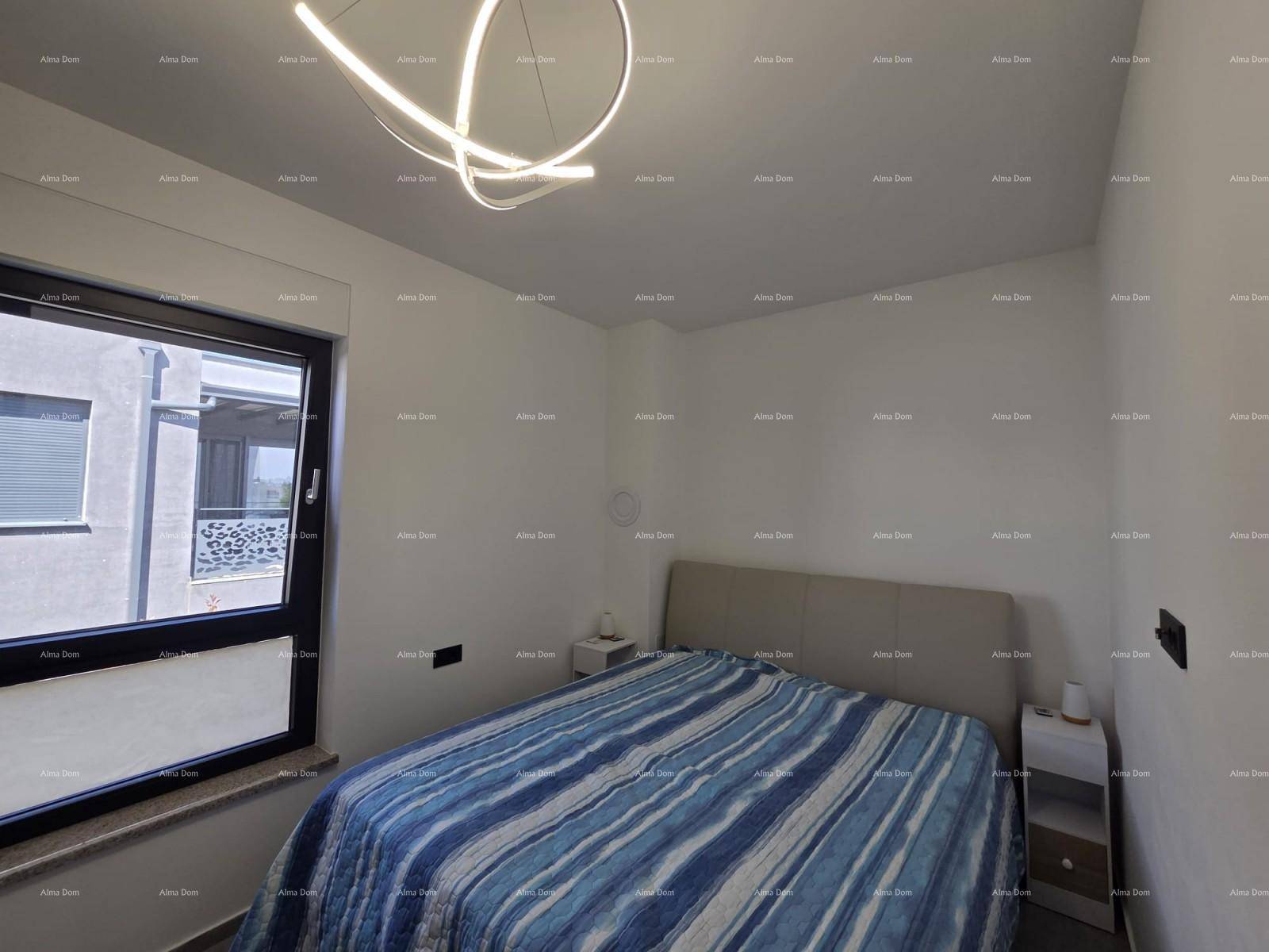 Gemütliches Schlafzimmer mit Doppelbett, modernem Deckenlicht und Fenster mit Blick nach draußen.