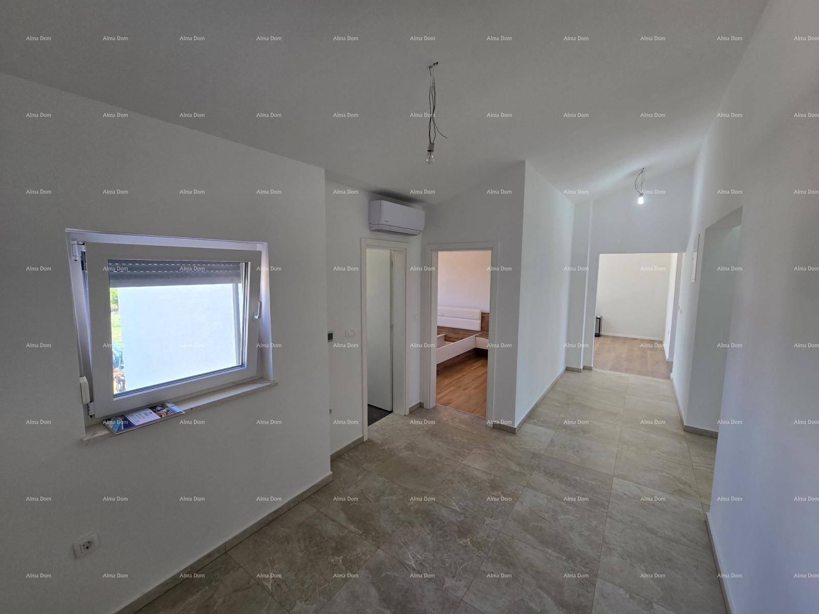 Heller Flur mit Fliesenboden, Fenster und Klimaanlage, der zu weiteren Zimmern führt.