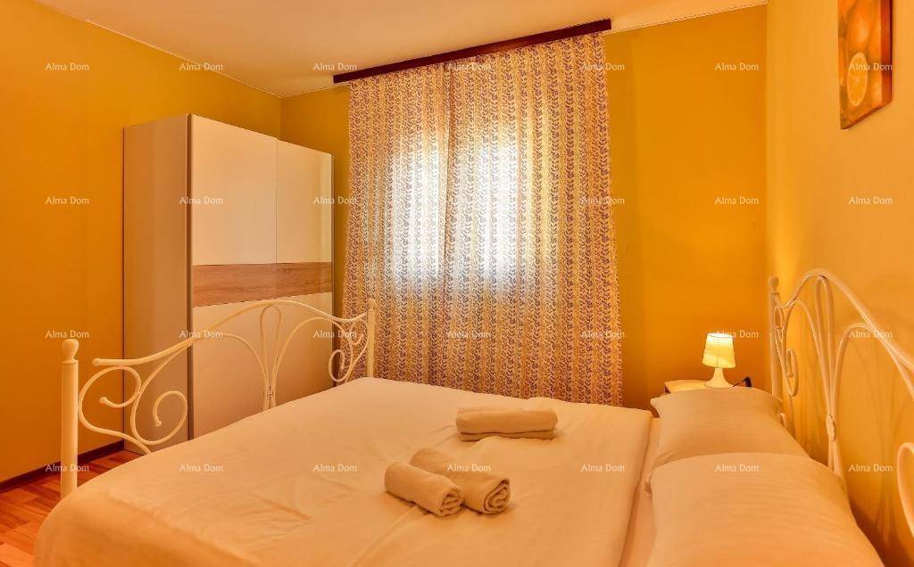Helles Schlafzimmer mit Doppelbett, weißem Kleiderschrank und gelben Wänden.