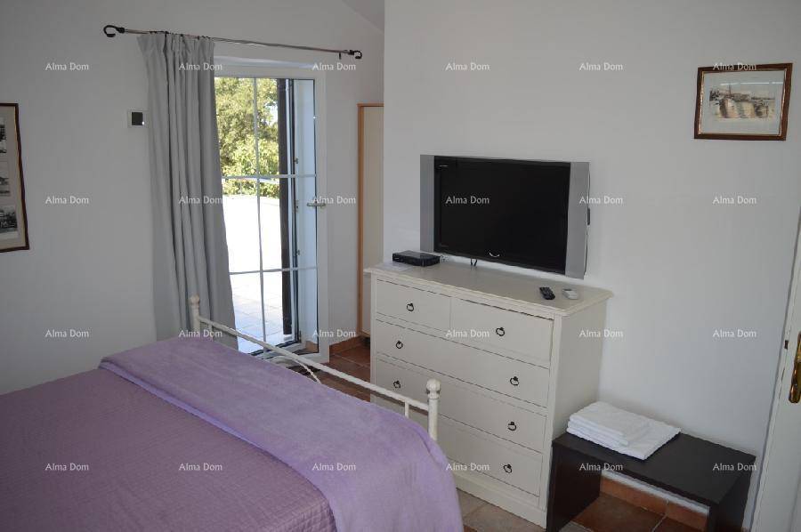 Schlafzimmer mit Doppelbett, Kommode und Zugang zu einem Balkon, hell und funktional eingerichtet.