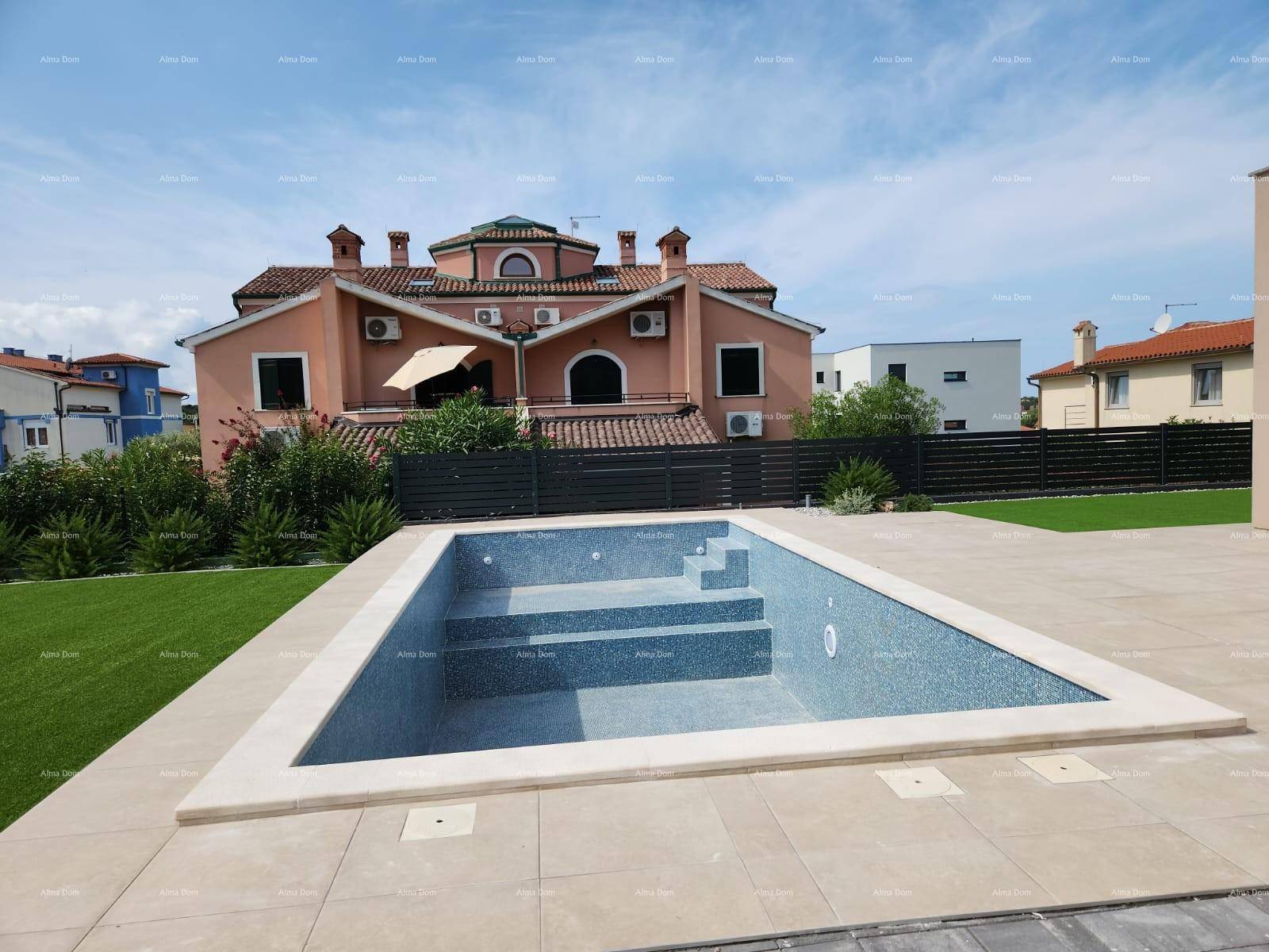 Außenpoolbereich mit gepflegtem Rasen und Terrasse, umgeben von traditioneller Architektur.