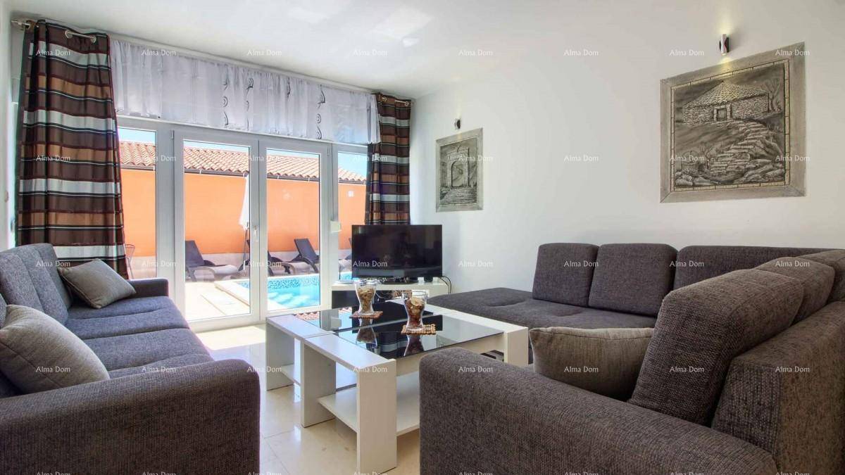 Gemütliches Wohnzimmer mit bequemen Sofas und direktem Zugang zum Poolbereich durch große Glastüren.