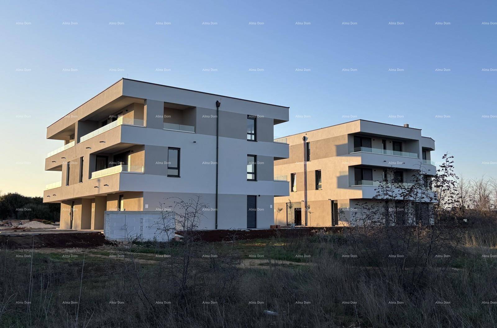 Zwei moderne Wohngebäude in der Abendsonne, umgeben von unbebautem Land.