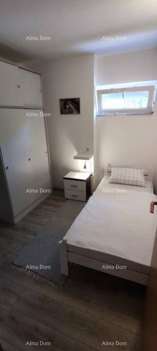 Schlafzimmer mit Einzelbett, großem Kleiderschrank und Fenster für viel Tageslicht.