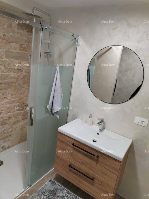 Modernes Badezimmer mit begehbarer Dusche, Holzwaschtisch und rundem Spiegel, kombiniert Stil und Funktionalität.