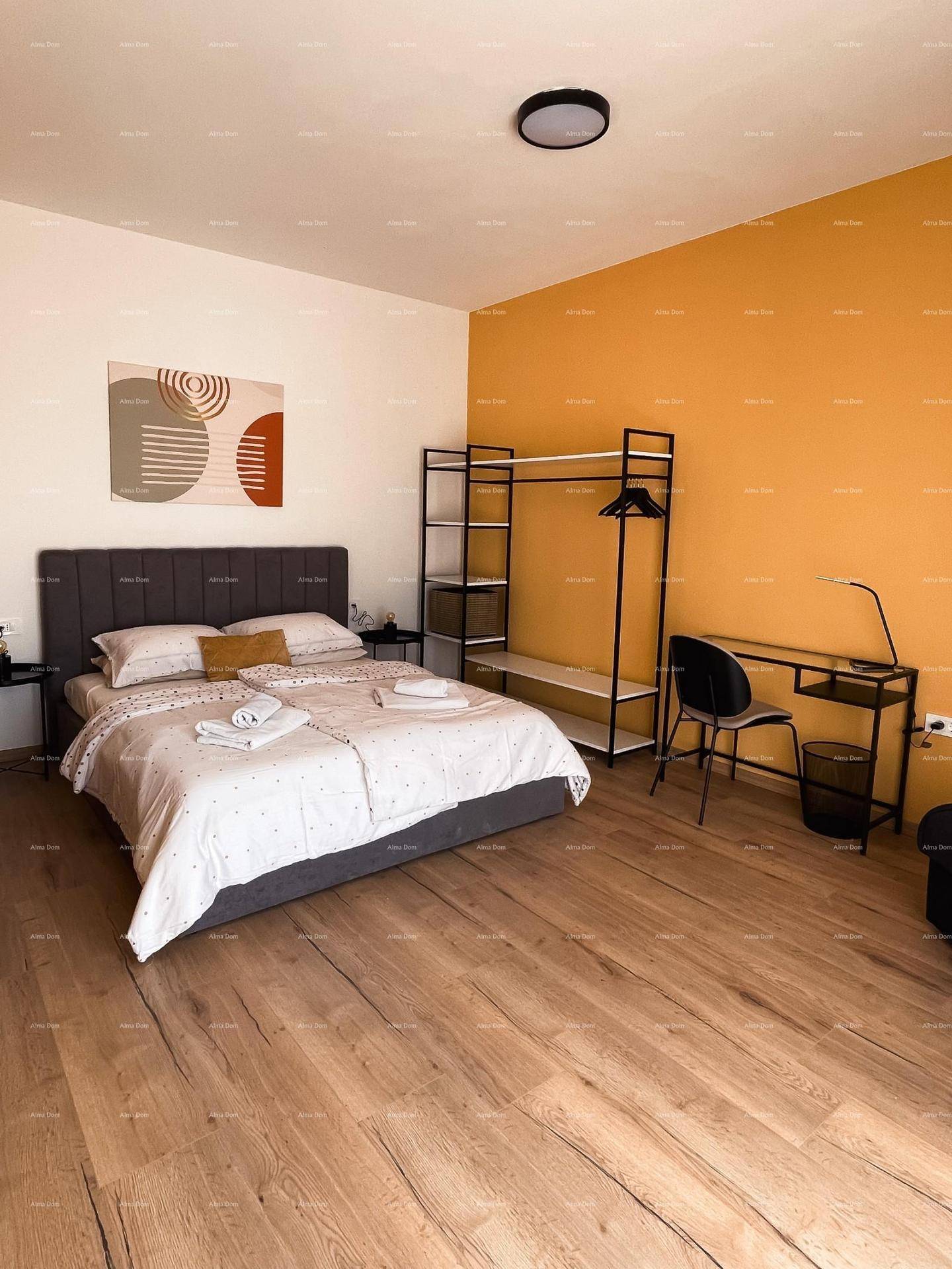 Modernes Schlafzimmer mit Holzboden, Doppelbett und offener Kleiderstange.