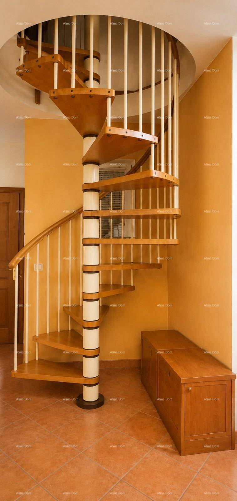 Wendeltreppe aus Holz mit weißem Geländer und einer passenden Holzbank im Flurbereich.