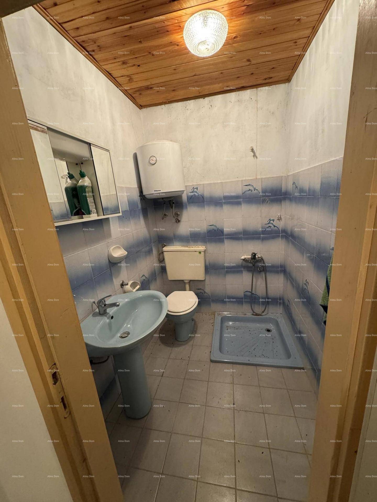 Badezimmer mit blauen Fliesen, Dusche, WC und Waschbecken im Stil der 80er Jahre.