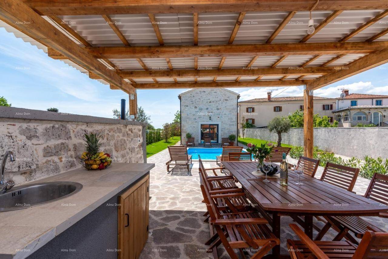 Überdachte Terrasse mit Außenküche, Spülbecken und großem Esstisch, perfekt für gesellige Stunden am Pool.