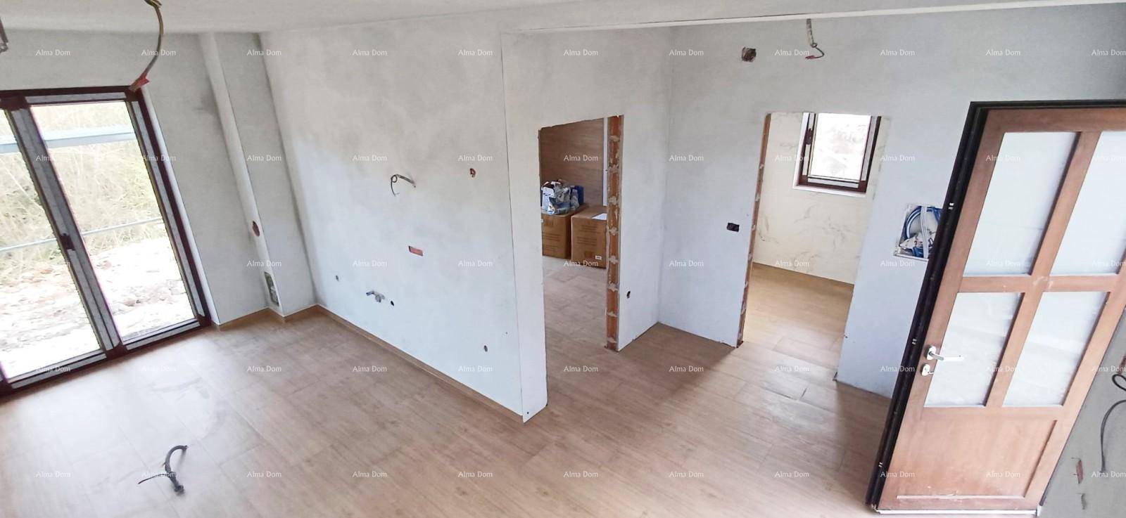 Lichtdurchfluteter Wohnbereich im Rohbau mit großen Schiebetüren und Holzboden.
