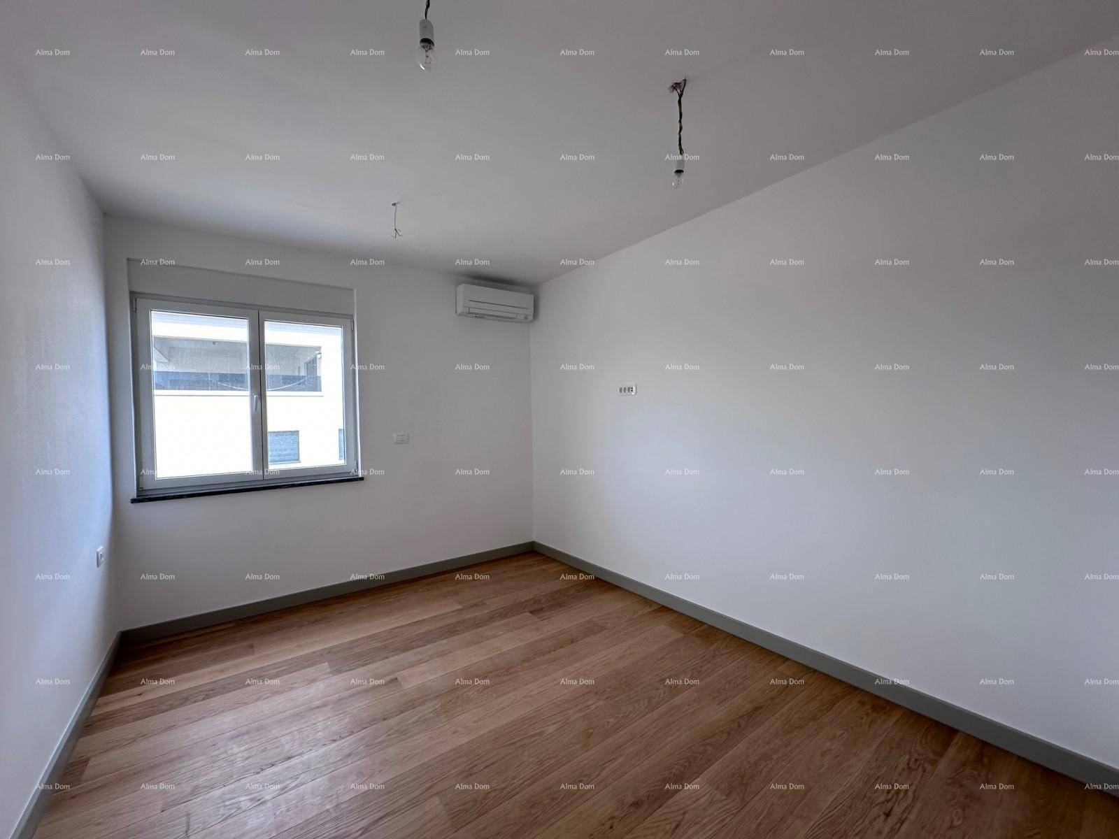 Helles Schlafzimmer mit Holzboden, Klimaanlage und großem Fenster für viel Tageslicht.