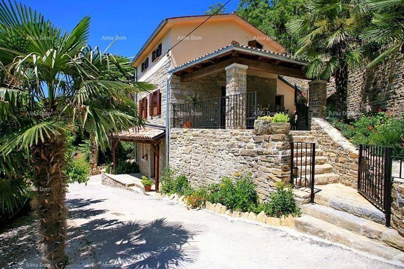 Traditionelles Steinhaus mit Balkon, Auffahrt und mediterraner Bepflanzung.