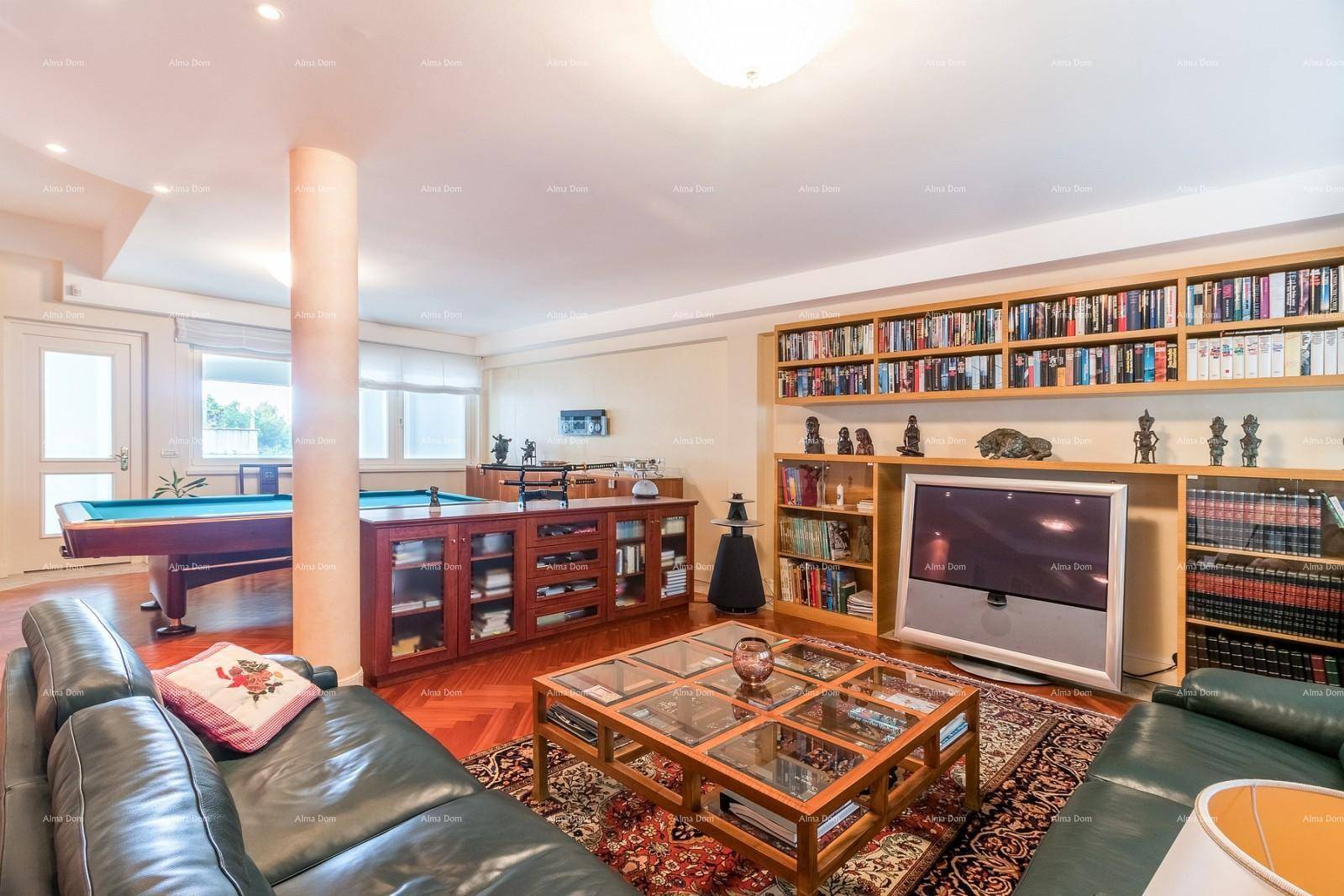 Unterhaltungsraum mit Billardtisch, Bücherregalen und gemütlichen Ledersofas.