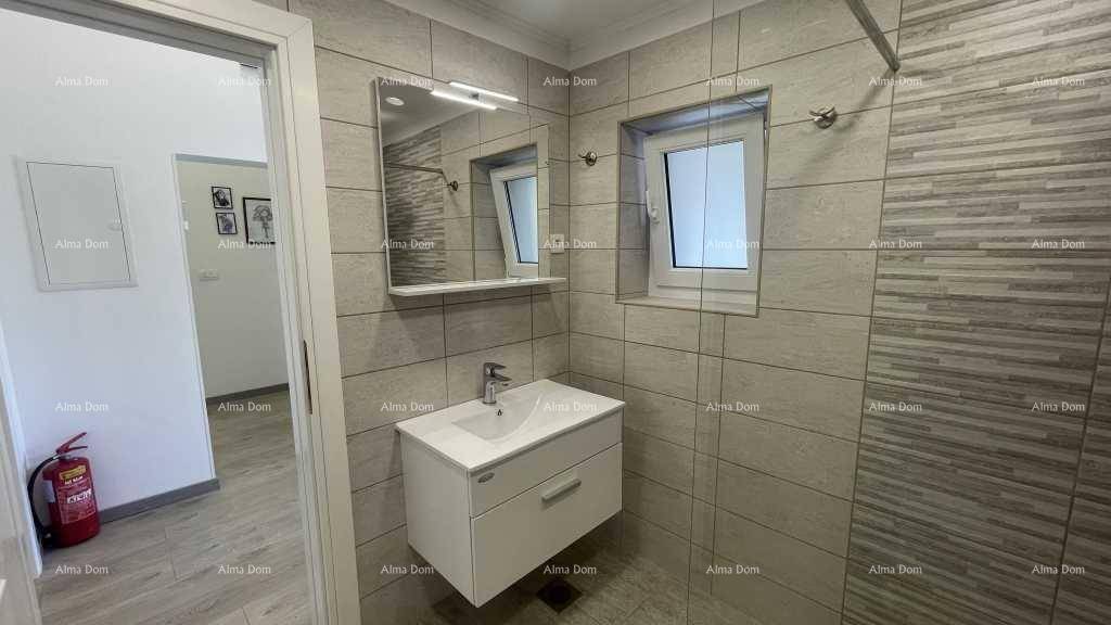 Helles Badezimmer mit modernem Waschtisch, Spiegelschrank und Fenster für Tageslicht.