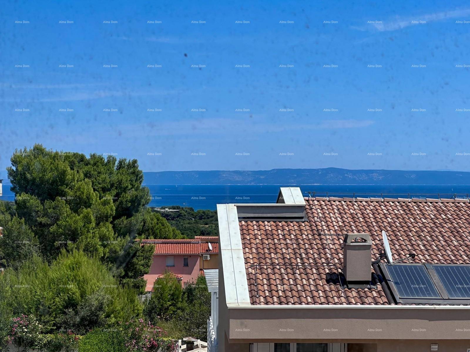 Panoramablick über ein Ziegeldach mit Solaranlage auf das weite Meer und die Küste.