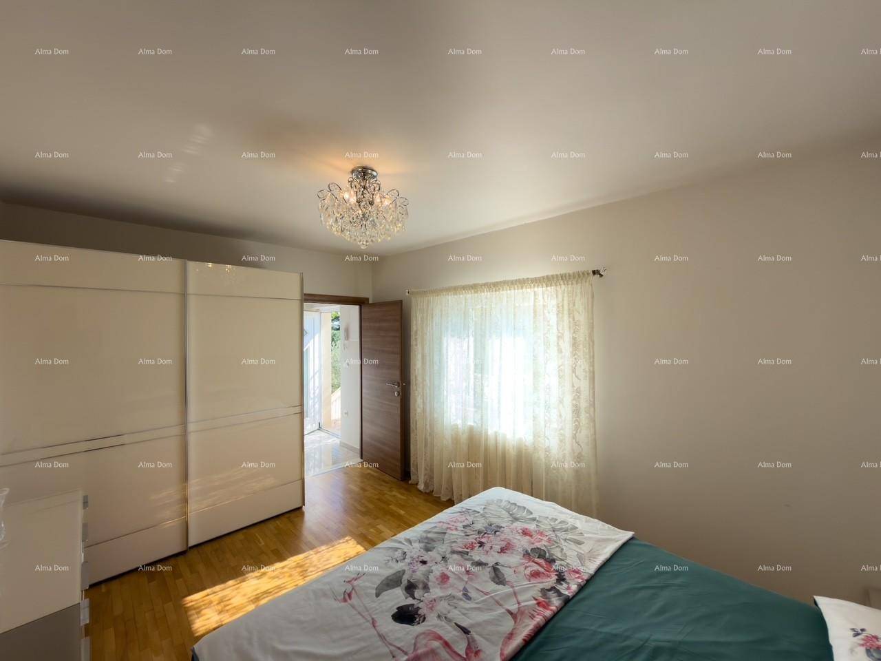 Helles Schlafzimmer mit Holzboden, großem Fenster und Zugang zu einem Außenbereich.