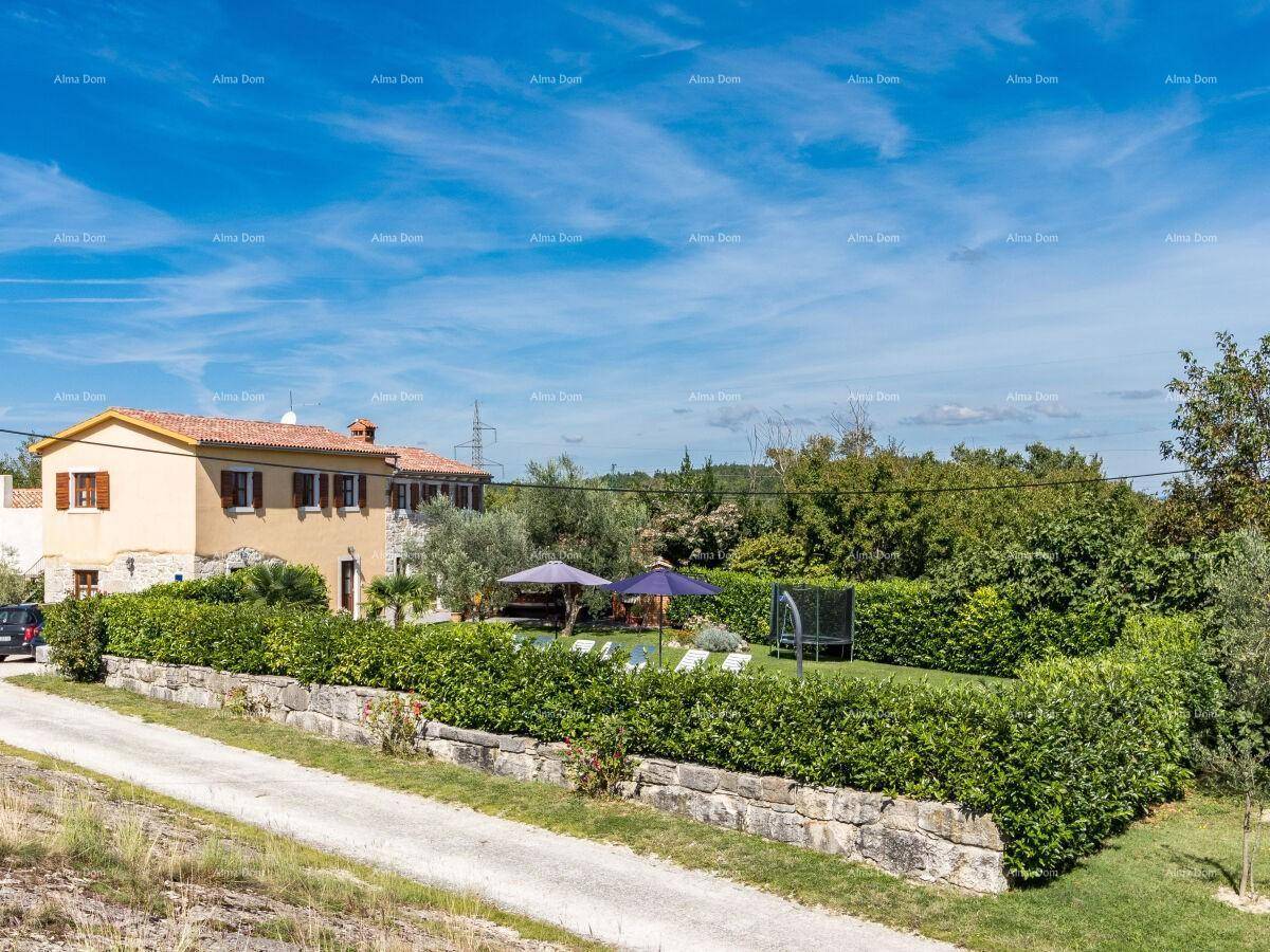 Weitläufiger Außenbereich mit Pool, Garten und traditionellem Haus im Hintergrund.