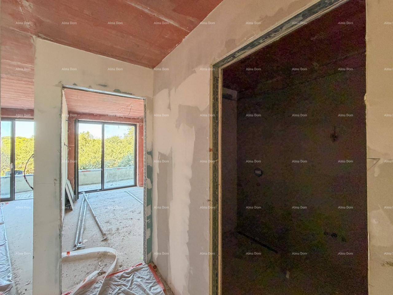 Flur im Rohbau mit Türrahmen und weitem Blick durch große Fenster auf die grüne Umgebung.
